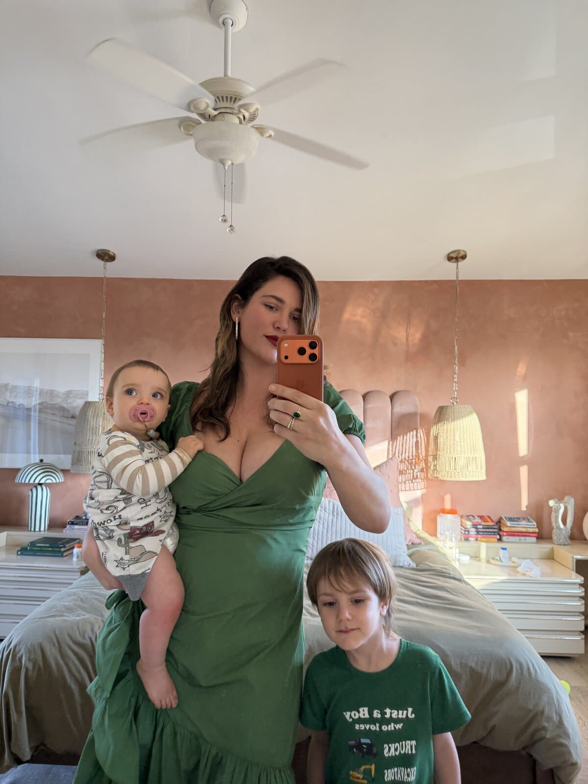 Ali Tate Cutler in an emerald green dress with her two children, terracotta bedroom backdrop. Mother of two, founder of Unfckwithable.